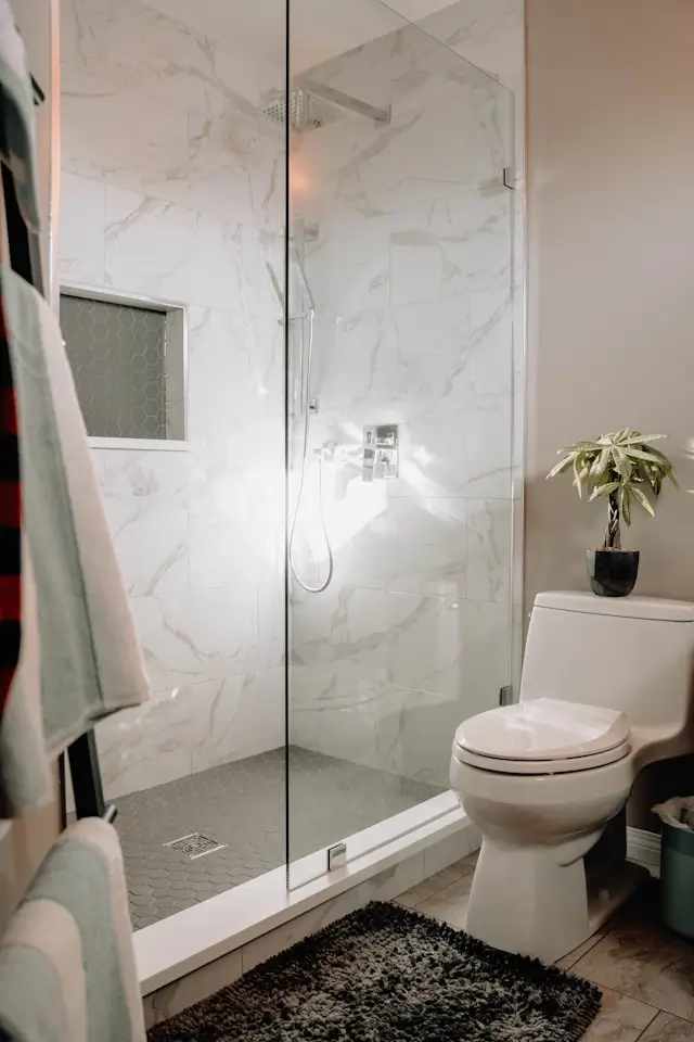 Marble walk-in shower with glass enclosure